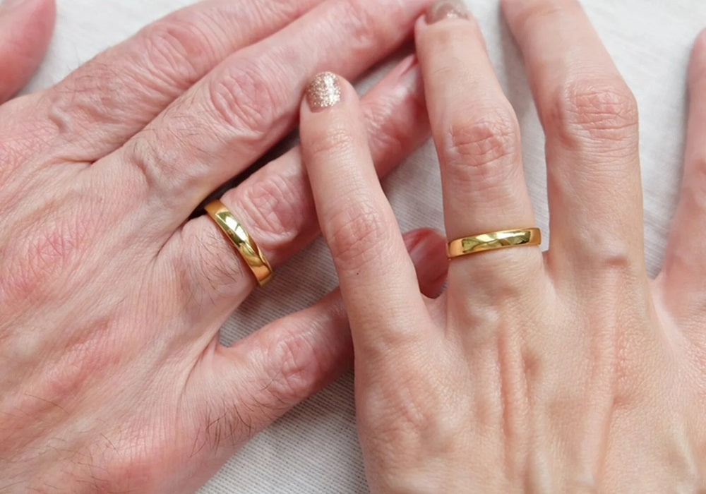 A slender hand wearing a diamond wedding Ring on their ring finger