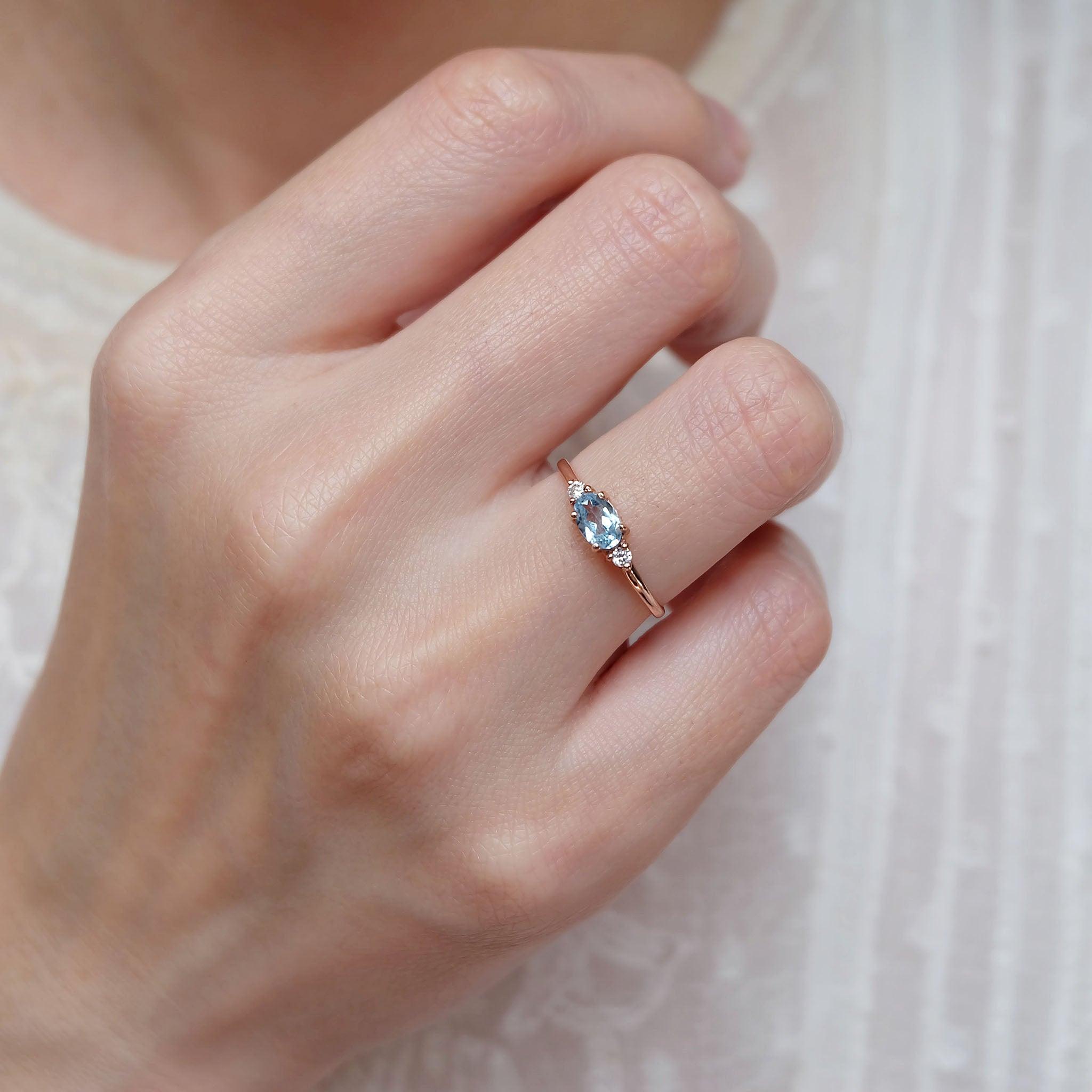 An aquamarine diamond ring worn on the right hand